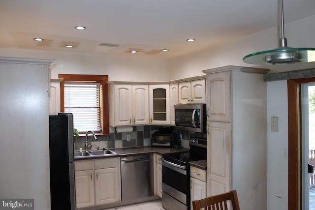 kitchen featuring light tile patterned floors, decorative light fixtures, stainless steel appliances, sink, and decorative backsplash