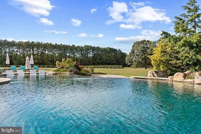 view of pool with a yard and pool water feature