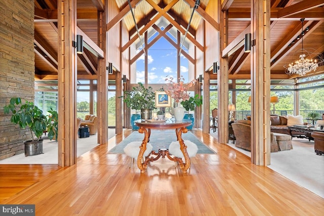 dining space featuring high vaulted ceiling, a chandelier, plenty of natural light, and hardwood / wood-style floors