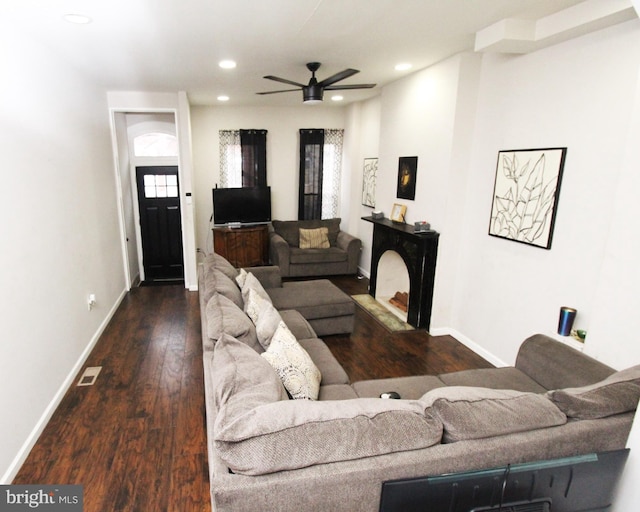 living room featuring ceiling fan and dark hardwood / wood-style flooring