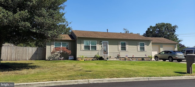 ranch-style home featuring a garage, a front yard, and fence