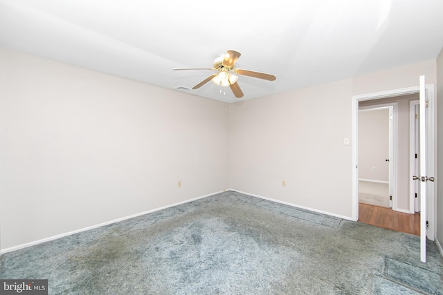 carpeted spare room with ceiling fan, visible vents, and baseboards