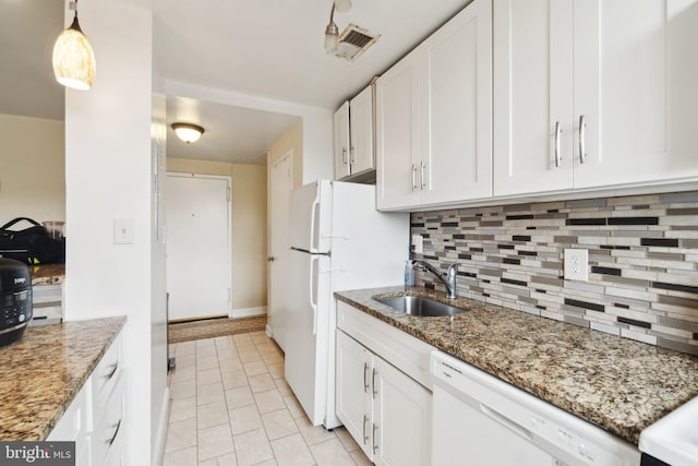 kitchen featuring dark stone counters, white appliances, sink, and white cabinets