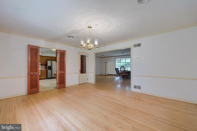 unfurnished room with light wood-type flooring, crown molding, plenty of natural light, and a chandelier