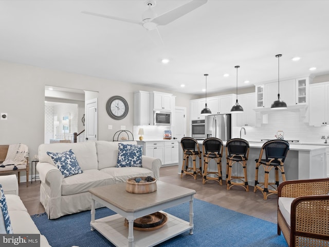 living room featuring ceiling fan and dark hardwood / wood-style flooring