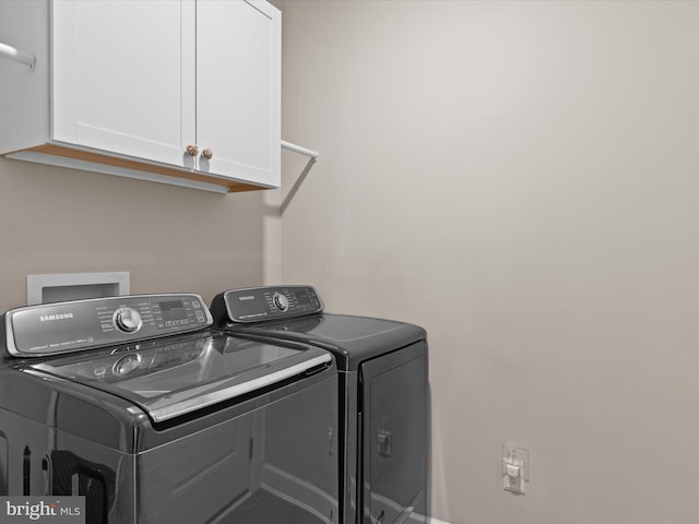 washroom featuring cabinets and separate washer and dryer