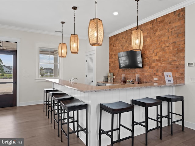 kitchen with pendant lighting, light stone counters, kitchen peninsula, and dark wood-type flooring