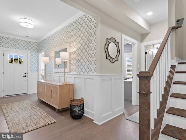 entryway with ornamental molding and dark hardwood / wood-style flooring