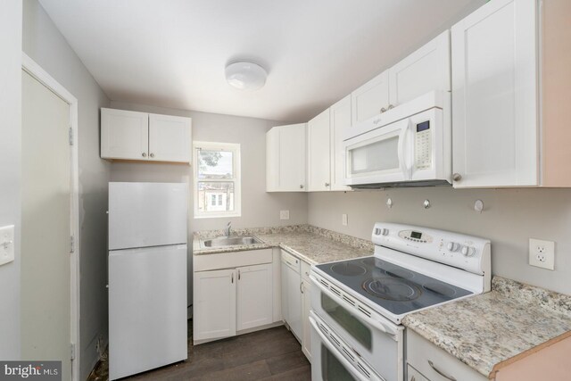 kitchen featuring dark hardwood / wood-style flooring, white cabinets, white appliances, and sink