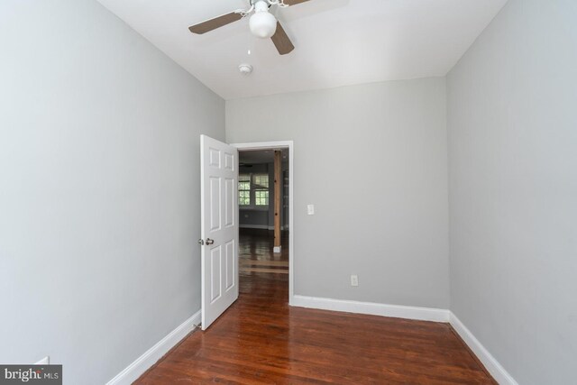 empty room with ceiling fan and dark wood-type flooring