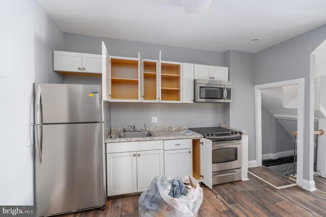 kitchen with white cabinetry, appliances with stainless steel finishes, and dark hardwood / wood-style flooring