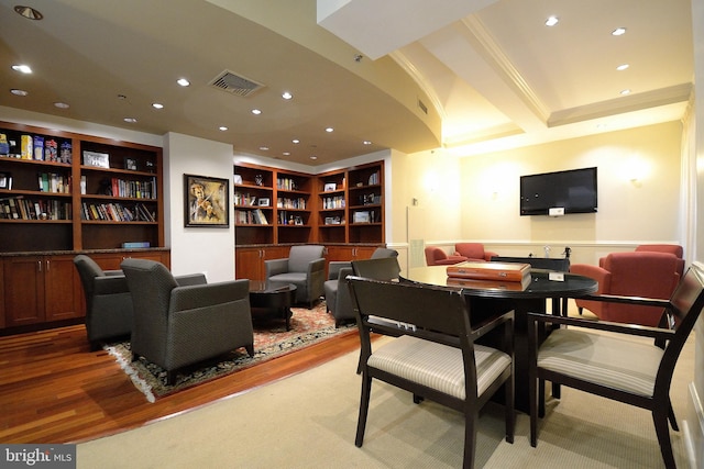 dining room with wood-type flooring, beam ceiling, and crown molding