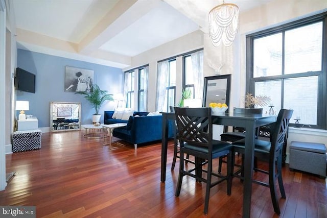 dining space featuring dark hardwood / wood-style flooring, a healthy amount of sunlight, and a notable chandelier