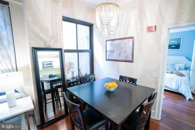 dining area featuring dark hardwood / wood-style floors and a notable chandelier