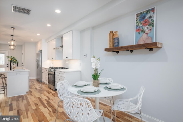 dining area with sink and light hardwood / wood-style floors