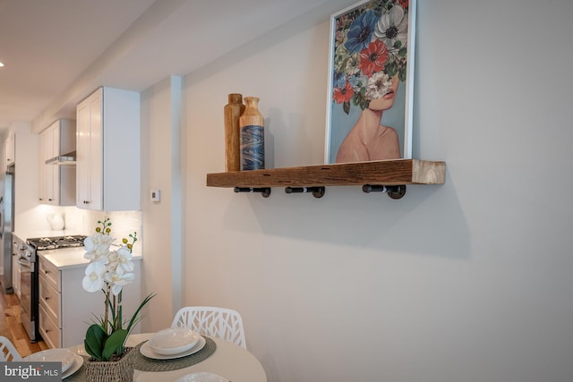 kitchen with light wood-type flooring, appliances with stainless steel finishes, and white cabinets