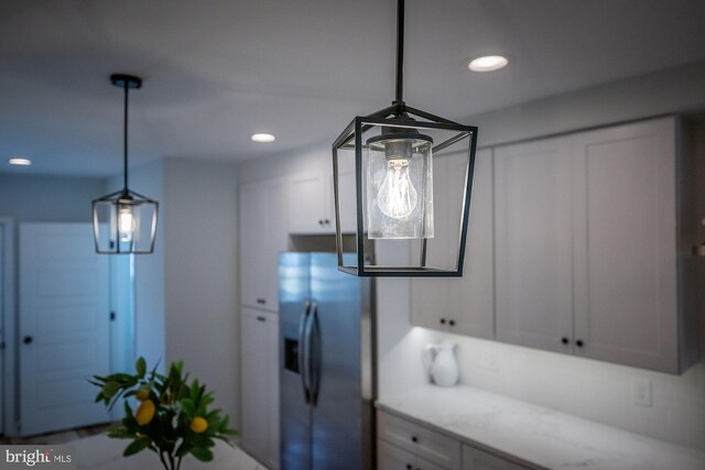 kitchen featuring a center island with sink, stainless steel dishwasher, sink, and decorative light fixtures