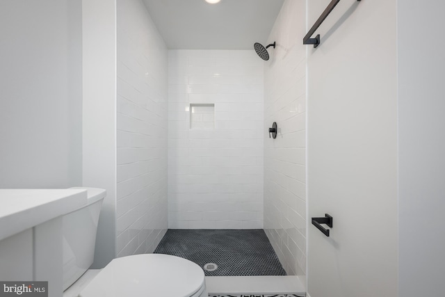 bathroom with tiled shower and toilet