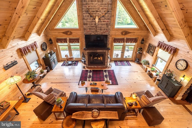 living room with a stone fireplace, beam ceiling, and a wealth of natural light