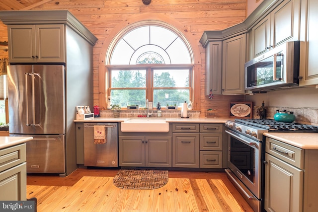 kitchen featuring wood ceiling, sink, light hardwood / wood-style flooring, gray cabinets, and high quality appliances