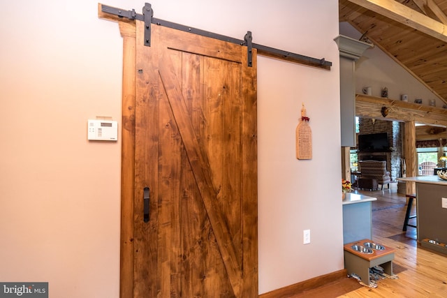 interior details with beam ceiling, wooden ceiling, hardwood / wood-style floors, and a barn door