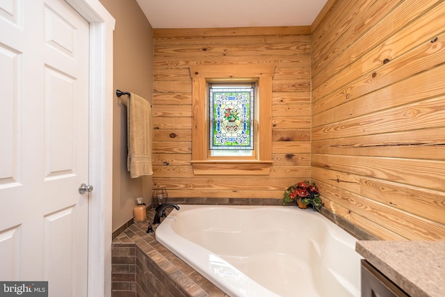 bathroom featuring vanity, a relaxing tiled tub, and wood walls