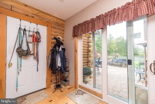 doorway with wood-type flooring, log walls, and french doors