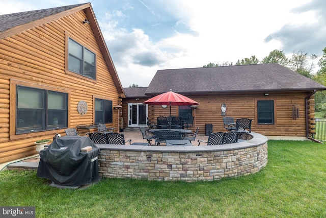 rear view of house with a lawn, a patio area, and an outdoor fire pit