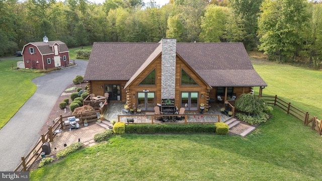 back of property featuring a lawn and a deck