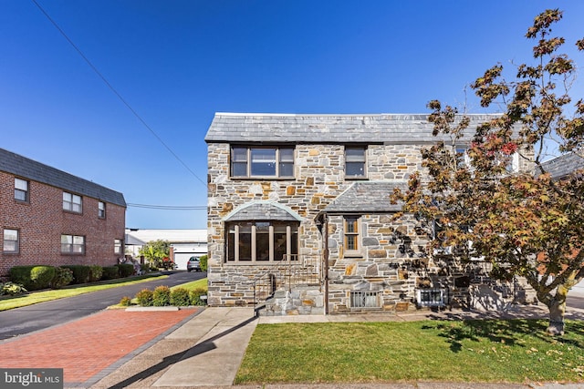 view of front of property featuring a garage and a front lawn