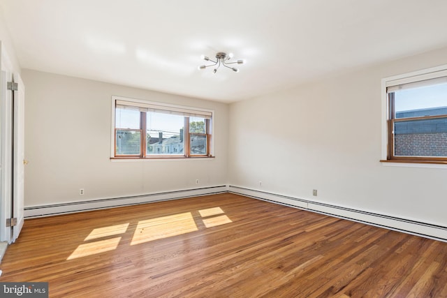 spare room with a baseboard radiator and hardwood / wood-style flooring