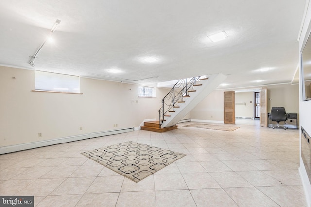 basement featuring a textured ceiling, a baseboard radiator, rail lighting, and light tile patterned flooring