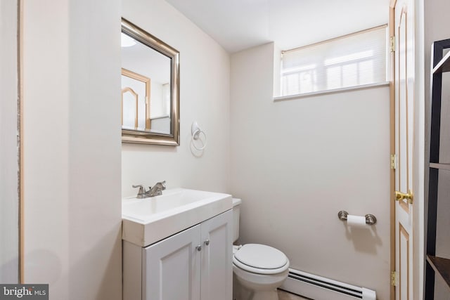 bathroom with a baseboard heating unit, vanity, and toilet