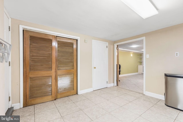 unfurnished bedroom with light tile patterned floors and a closet