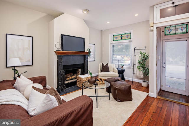 living room featuring dark wood-type flooring and a tile fireplace