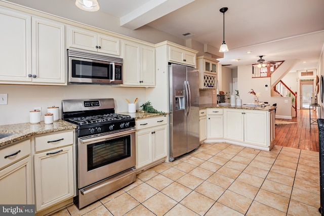 kitchen featuring light hardwood / wood-style floors, hanging light fixtures, stainless steel appliances, kitchen peninsula, and ceiling fan