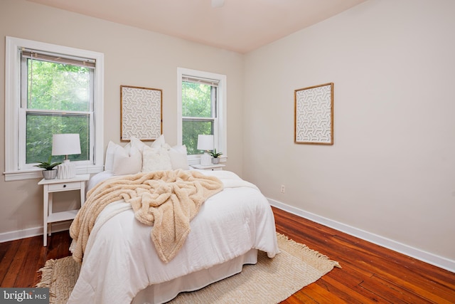 bedroom with dark hardwood / wood-style flooring