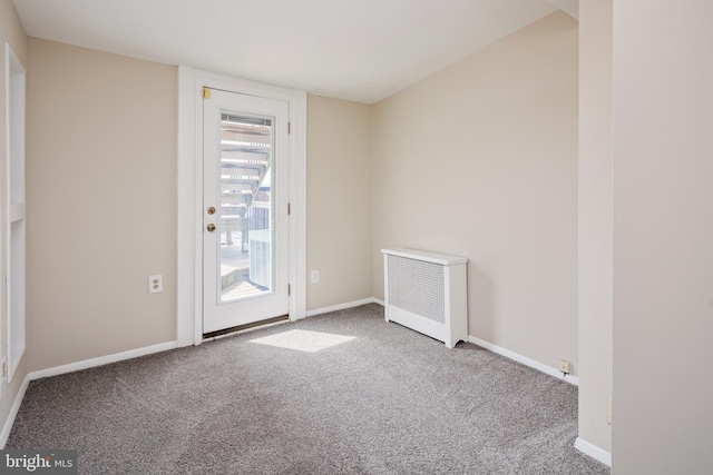 empty room with radiator heating unit and carpet floors