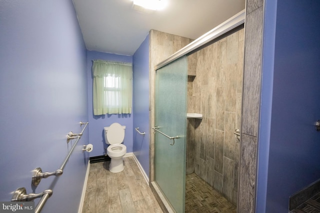 bathroom with hardwood / wood-style floors, toilet, and a shower with shower door