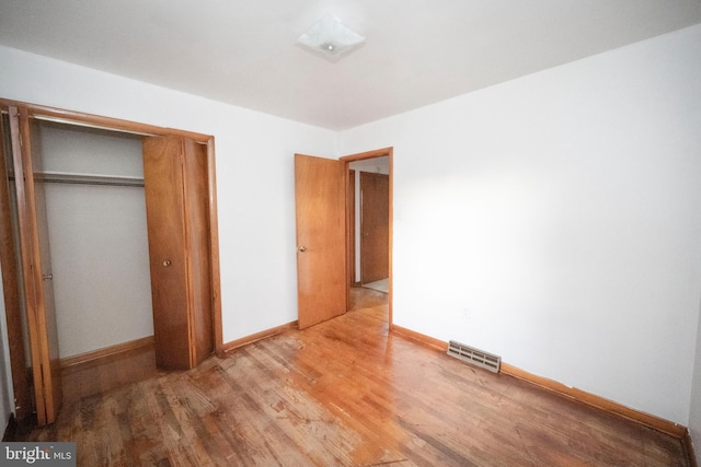 unfurnished bedroom with a closet and wood-type flooring