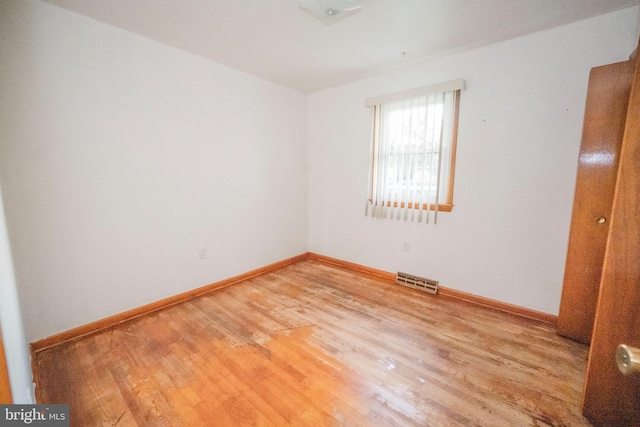 unfurnished room with hardwood / wood-style flooring