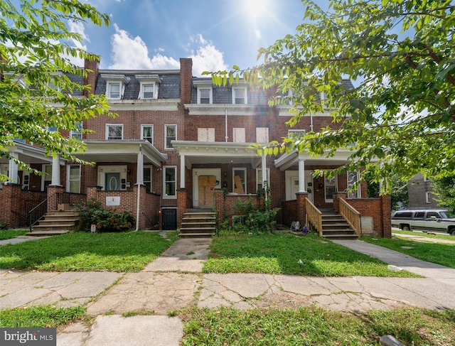 townhome / multi-family property featuring a porch and a front lawn