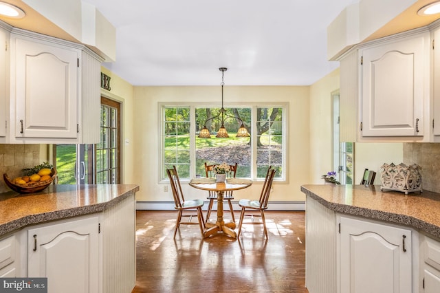 kitchen with dark wood-type flooring, decorative light fixtures, and white cabinets