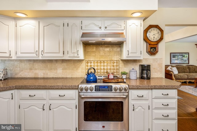 kitchen featuring white cabinets, decorative backsplash, extractor fan, and stainless steel range oven