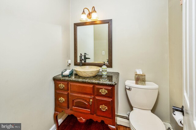 bathroom with vanity, toilet, and a baseboard radiator