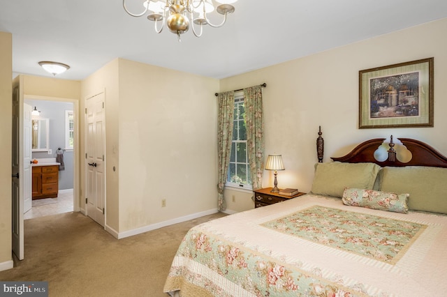 bedroom featuring a notable chandelier, ensuite bathroom, and light carpet