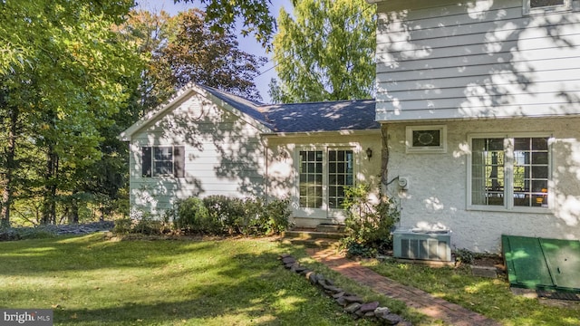 exterior space with a lawn and central AC unit