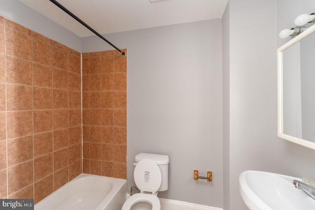 full bathroom with tiled shower / bath combo, toilet, and sink