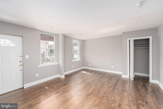 entryway with dark hardwood / wood-style flooring and a healthy amount of sunlight