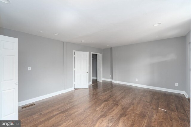 unfurnished room featuring dark wood-type flooring